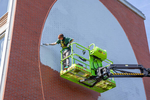 Janisdeman aan het werk aan muurschildering Overvecht